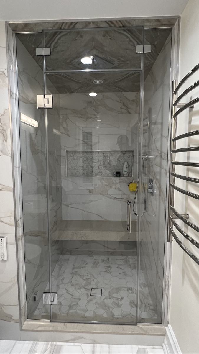 Frameless hinged shower door with chrome hardware