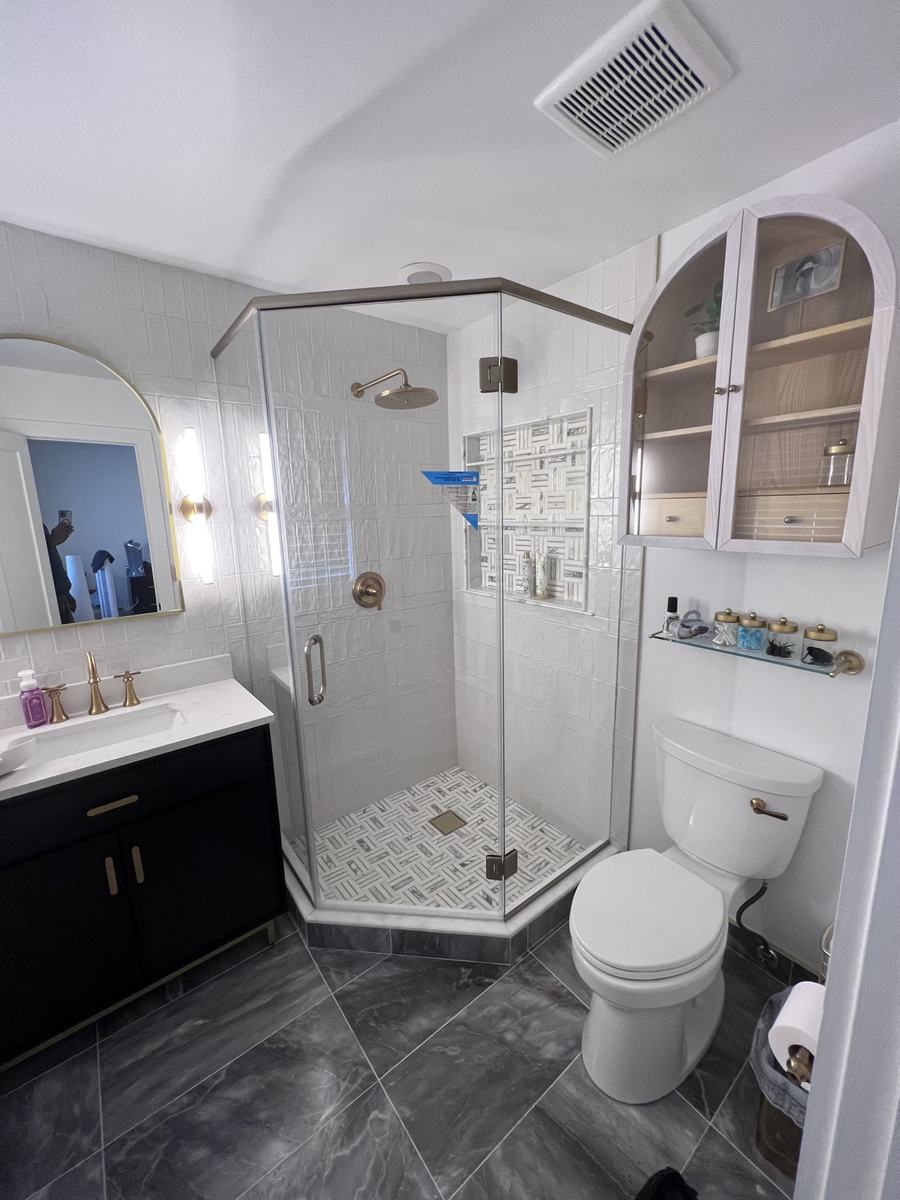 Frameless neo-angle shower enclosure with brushed nickel hardware