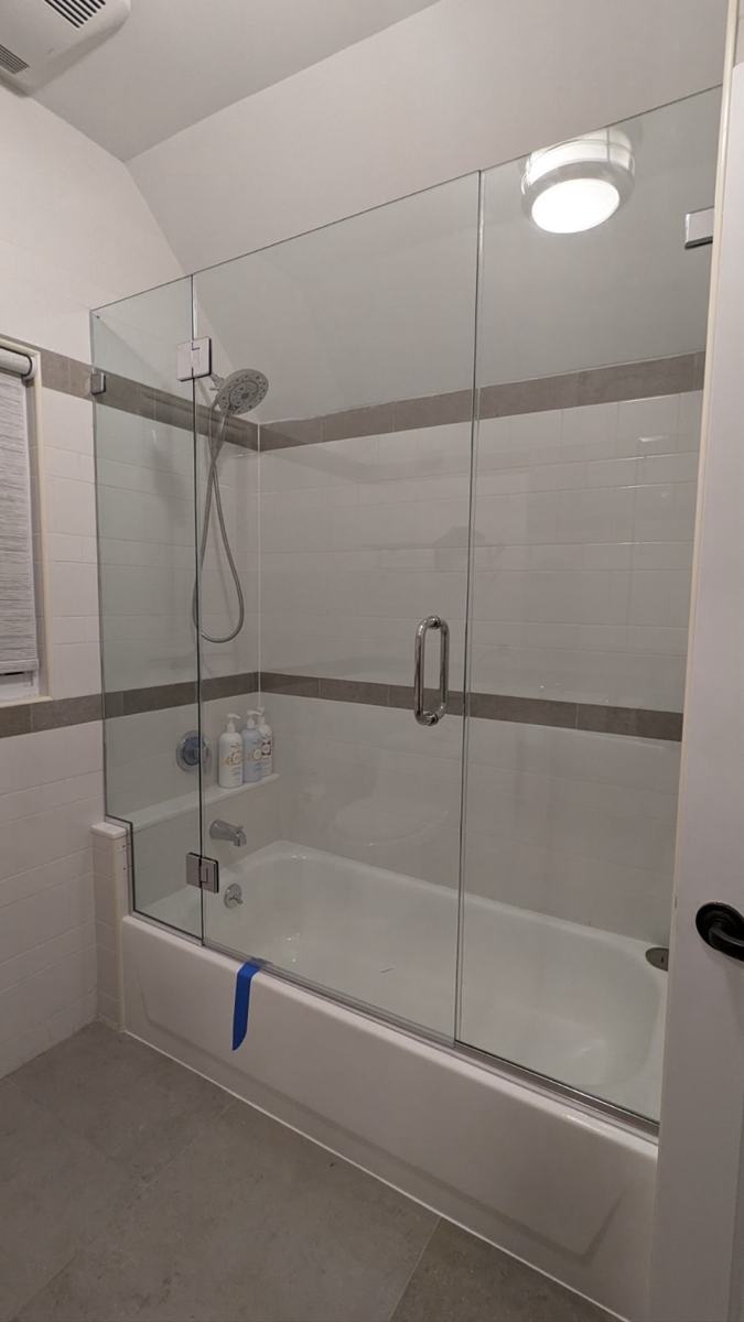 Frameless hinged tub enclosure with chrome hardware