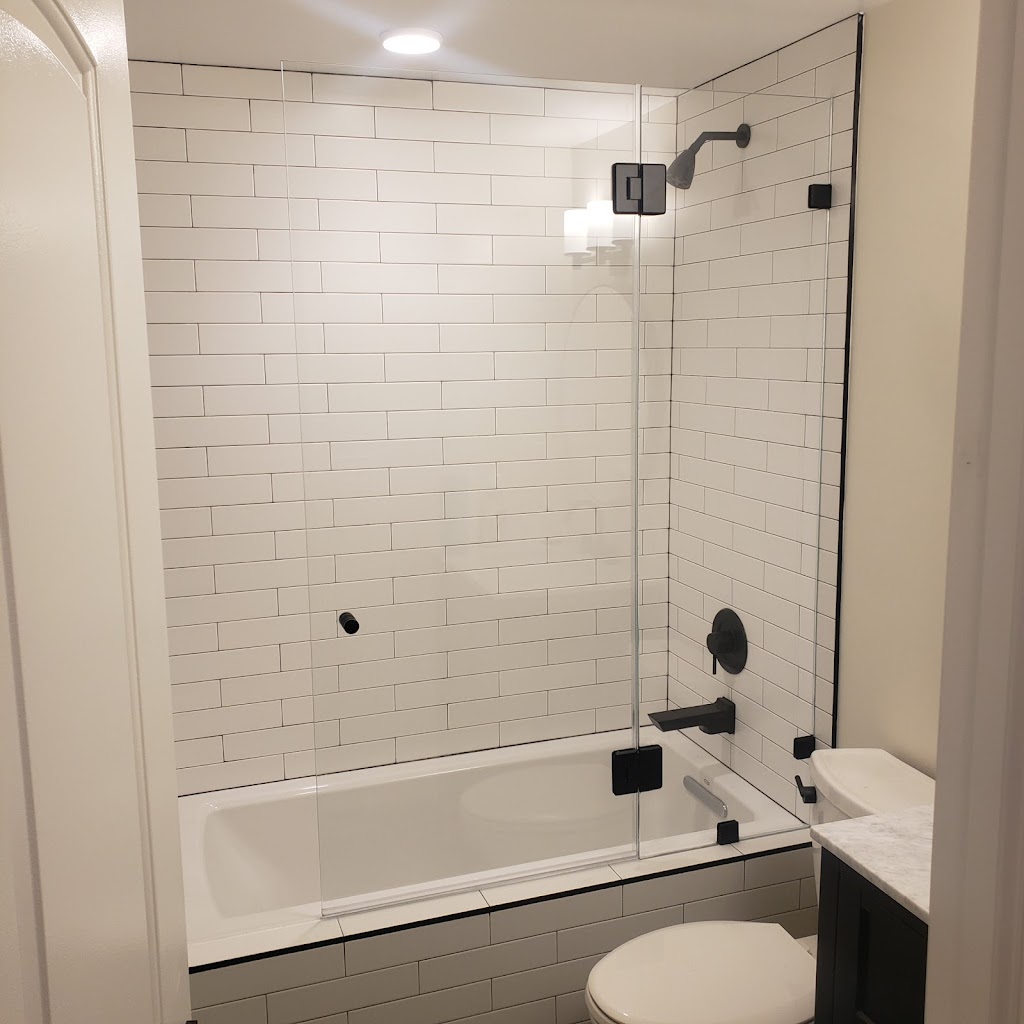 Custom frameless tub enclosure installed with matte black hardware