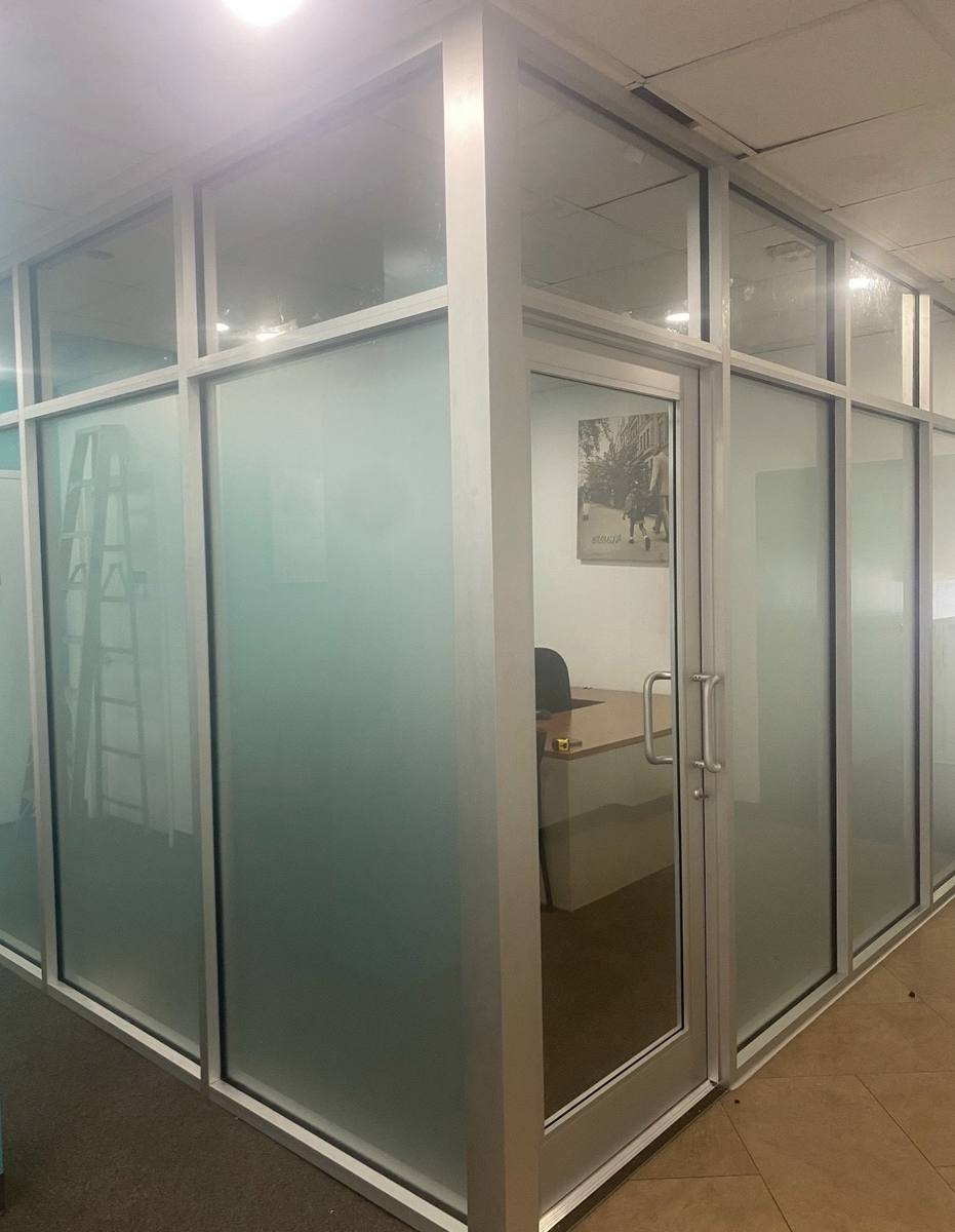 Glass office partition with frosted panels and glass door